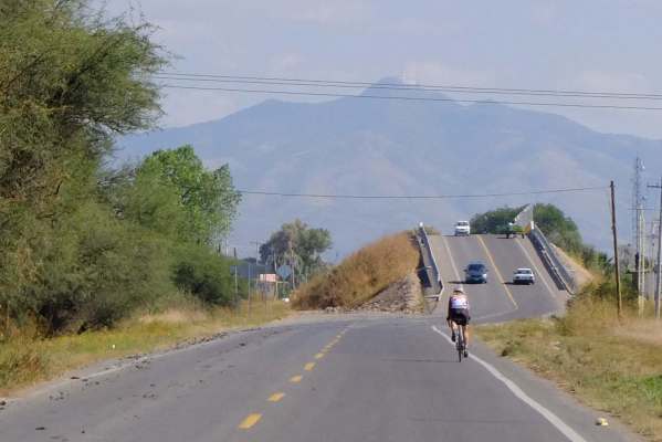 Beate rides towards the mountains near Guanajuato