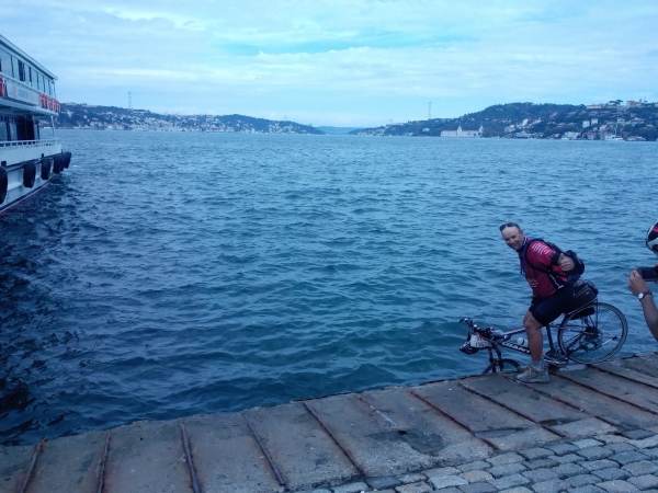 Lloyd dips his front tyre in to complete his round the world trip by bike