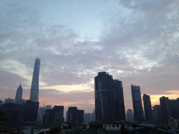 The sun peaks through the Shanghai skyline as riders prep for their first day of riding.