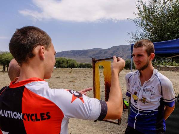 Will and Charlie study the fresh honey provided by a local man