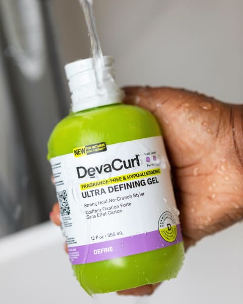 hand holding DevaCurl hypoallergenic hair gel bottle