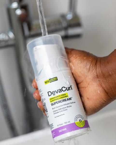 devacurl hypoallergenic curl cream bottle in hand