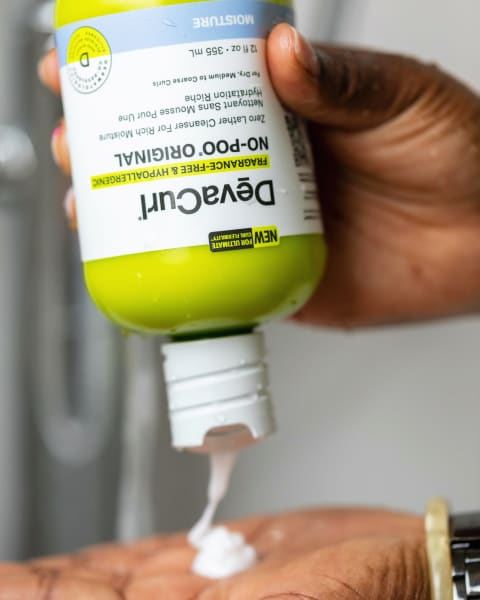 devacurl hypoallergenic shampoo for curly hair being squeezed into hand