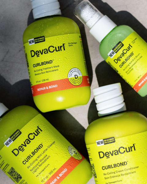 DevaCurl CurlBond™ products in bottles: recoiling serum, treatment mask, cleanser, and conditioner