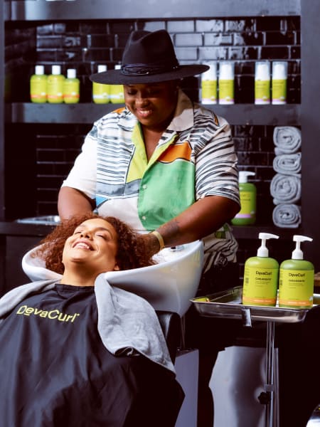 stylist with hands in hair at the sink