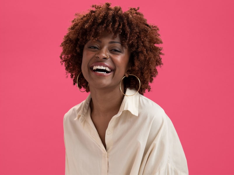 woman with coily hair laughing