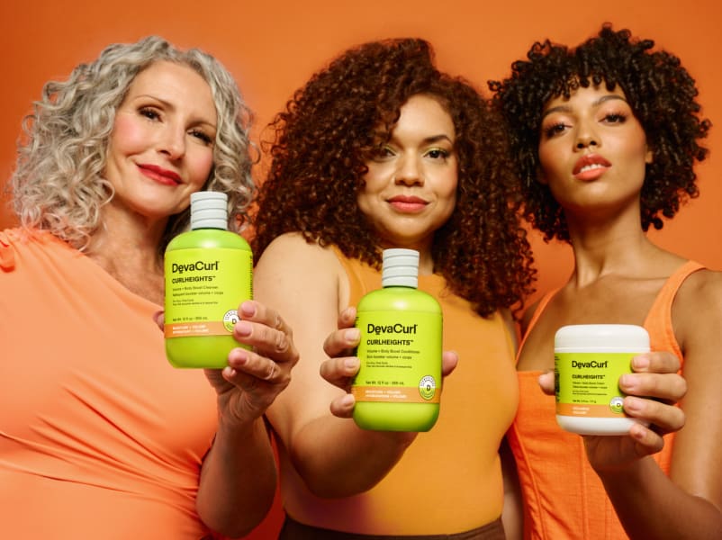 women with wavy, curly and coily hair holding CurlHeights bottles