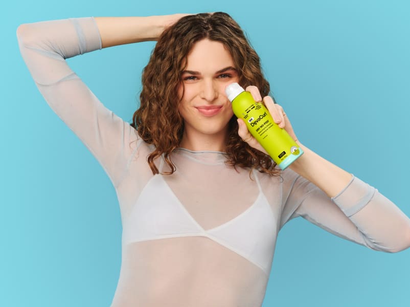 Woman with wavy hair holding Dry No-Poo can