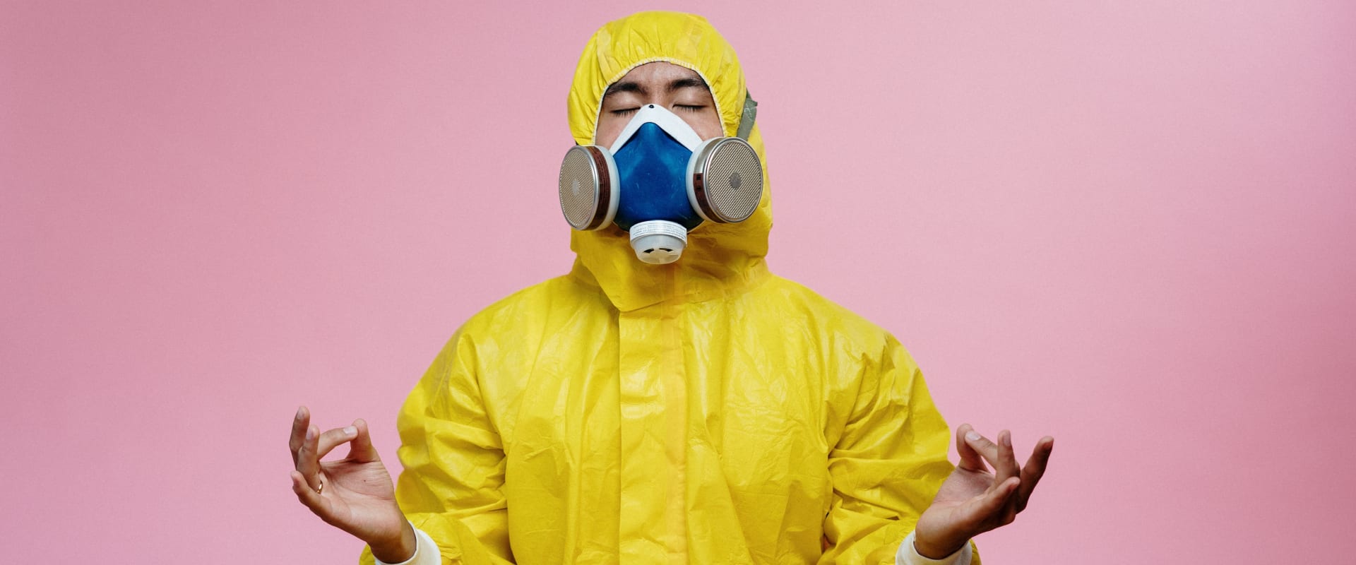 A person dressed in a bright yellow hazmat suit and respirator