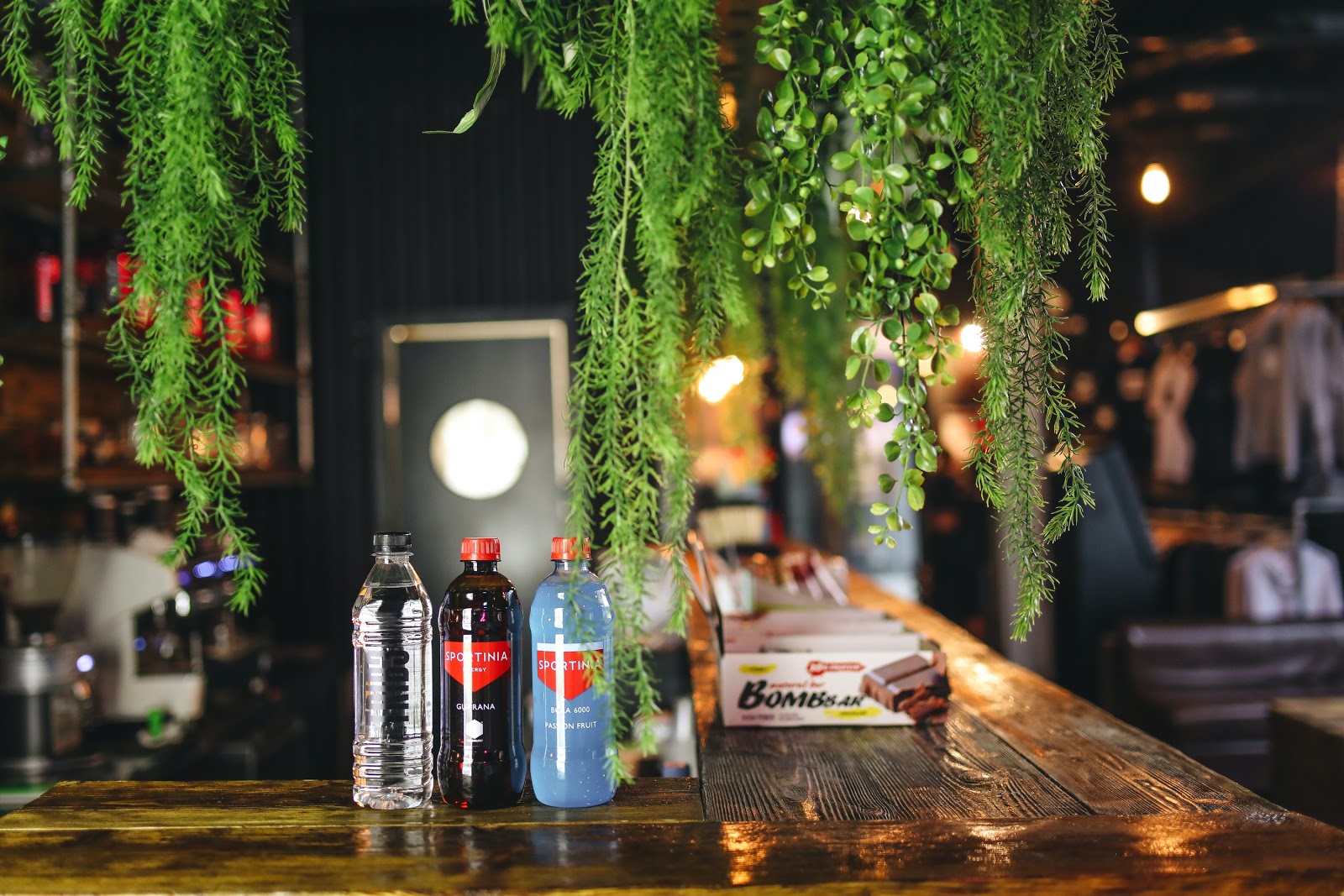 An attractive bar with overhanging green foliage featuring an array of bottled products.