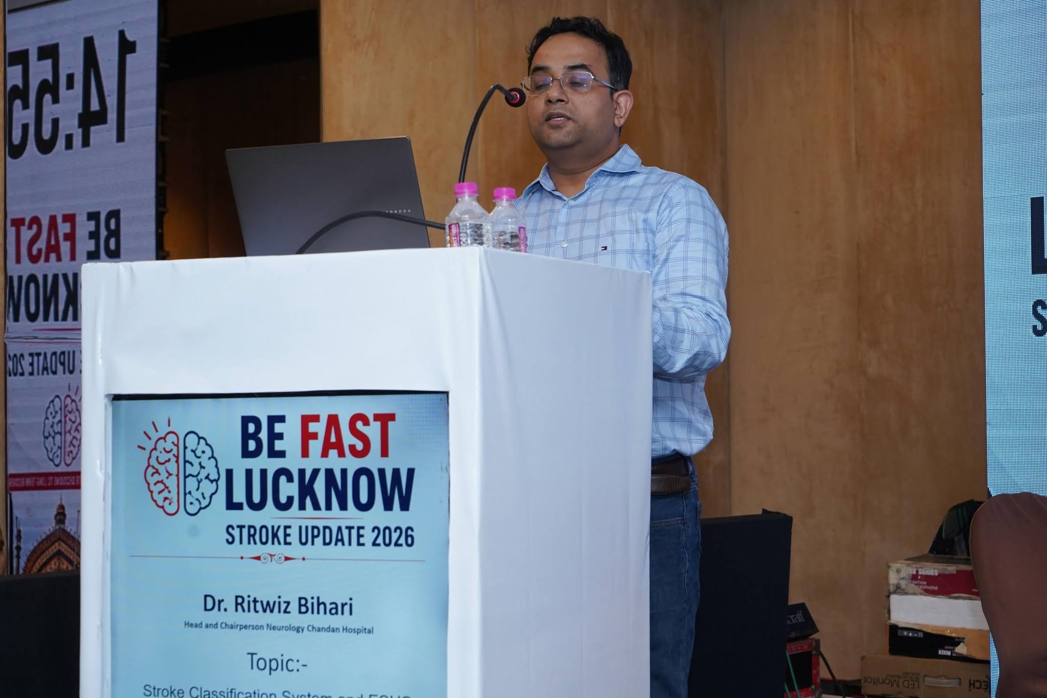 Dr. Ritwiz Bihari seated on stage alongside a fellow neurologist addressing the audience