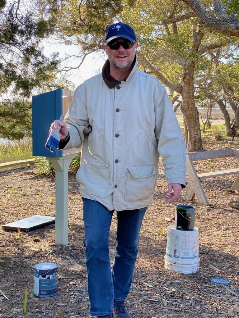 Chris paints the little free library