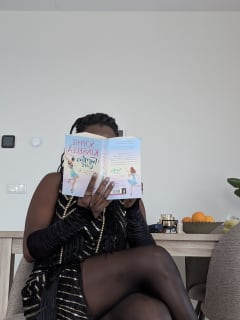 Olu dressed as a 20s girl, holding a copy of the Twenties Girl