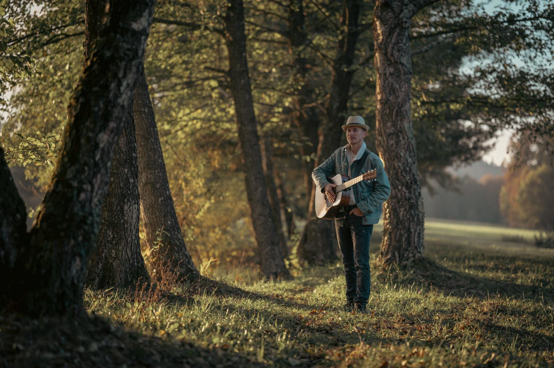 Kristjan Hočevar igra kitaro v gozdu
