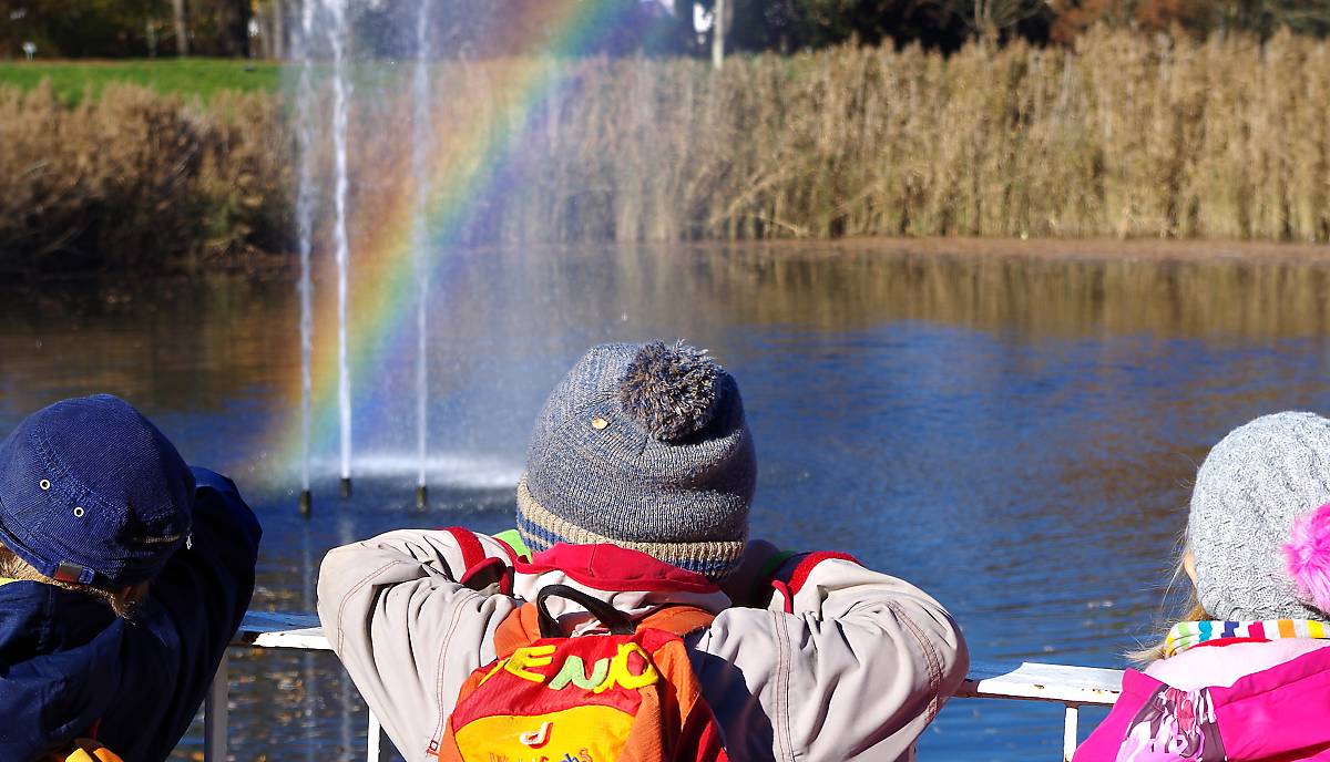 Kinder sehen einen Regenbogen