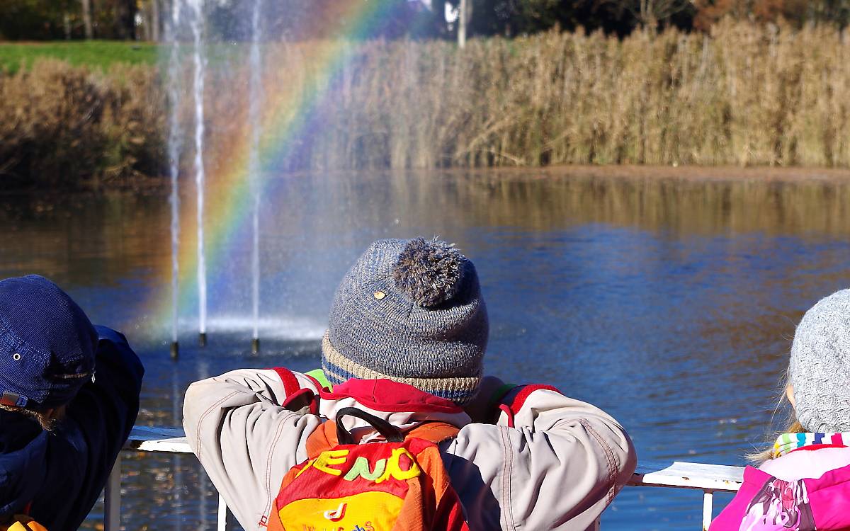 Kinder sehen einen Regenbogen