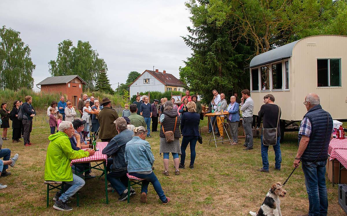 Gäste und Redner haben sich im Fledermausgarten versammelt. Links ist das Fledermausquartier zu sehen.