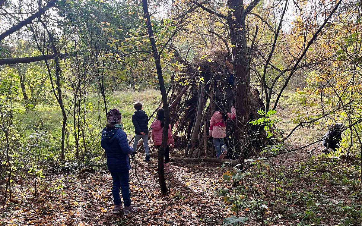 Kreatives Spiel: Aus gesammelten Ästen bauen die Kinder gemeinsam eine kleine Hütte.