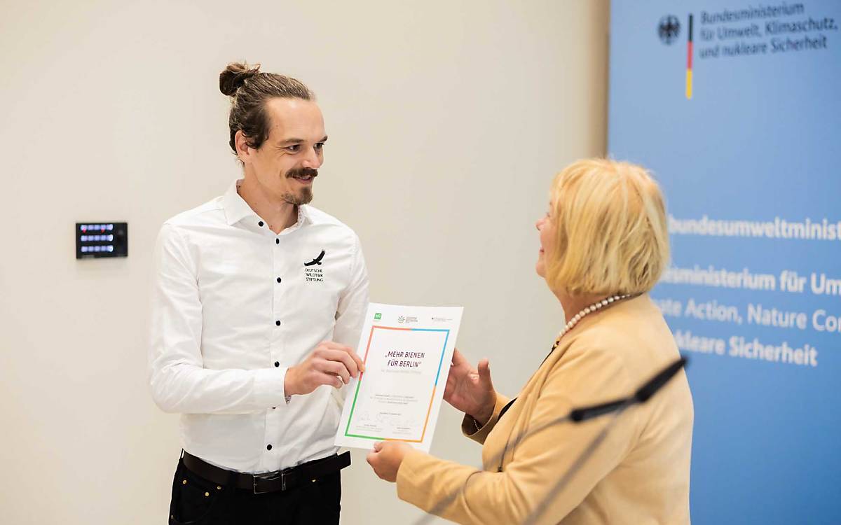 Bettina Hagedorn, Parlamentarische Staatssekretärin im Bundesumweltministerium, übergab die Preisurkunde an Tom Bluth aus unserem Berliner Wildbienen-Team.