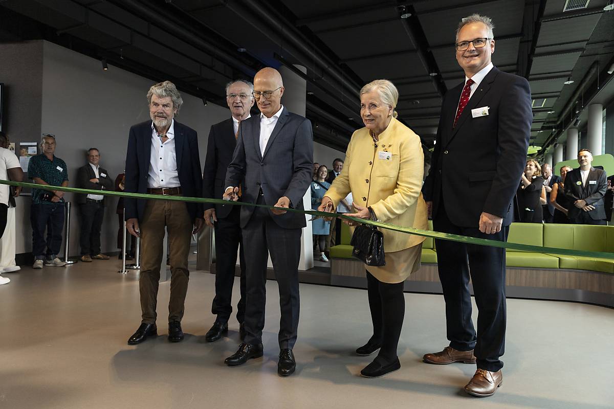 Ehrengäste durchschneiden das grüne Band zur Ausstellungseröffnung