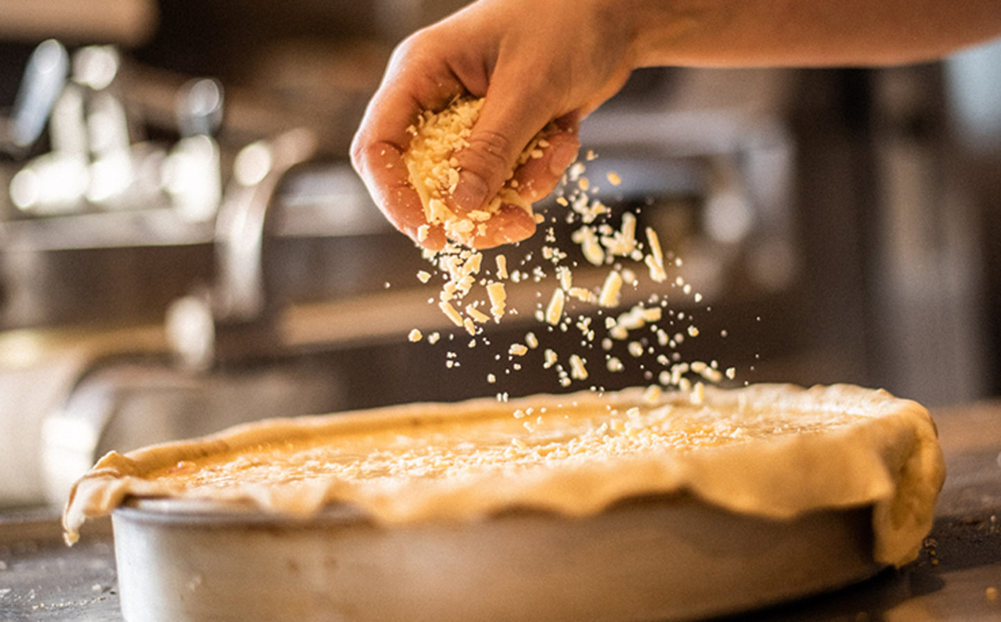 Baker putting toppings on pie