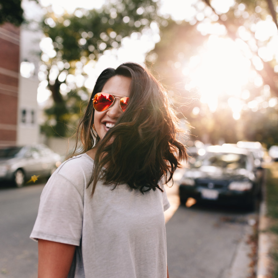 Woman smiling in the sunshine wearing sunglasses