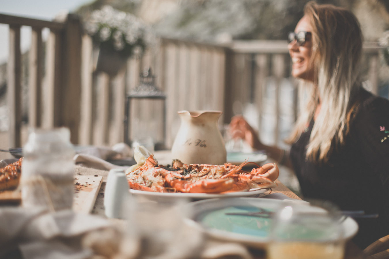 Fish for Thought lifestyle image of a woman eating lobster on a beach in Cornwall