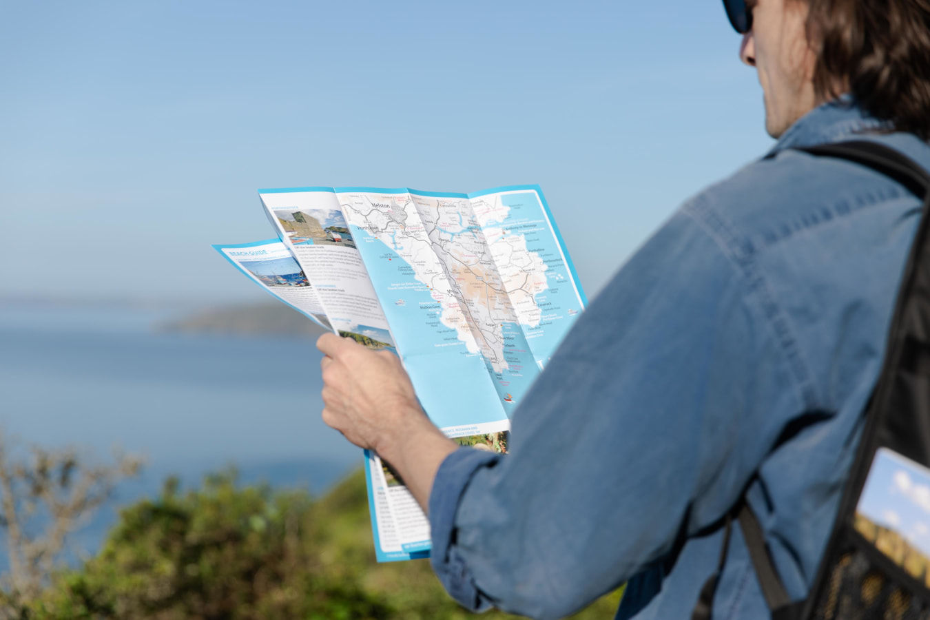 Person holding Friendly Guides Map on Cornish Coast