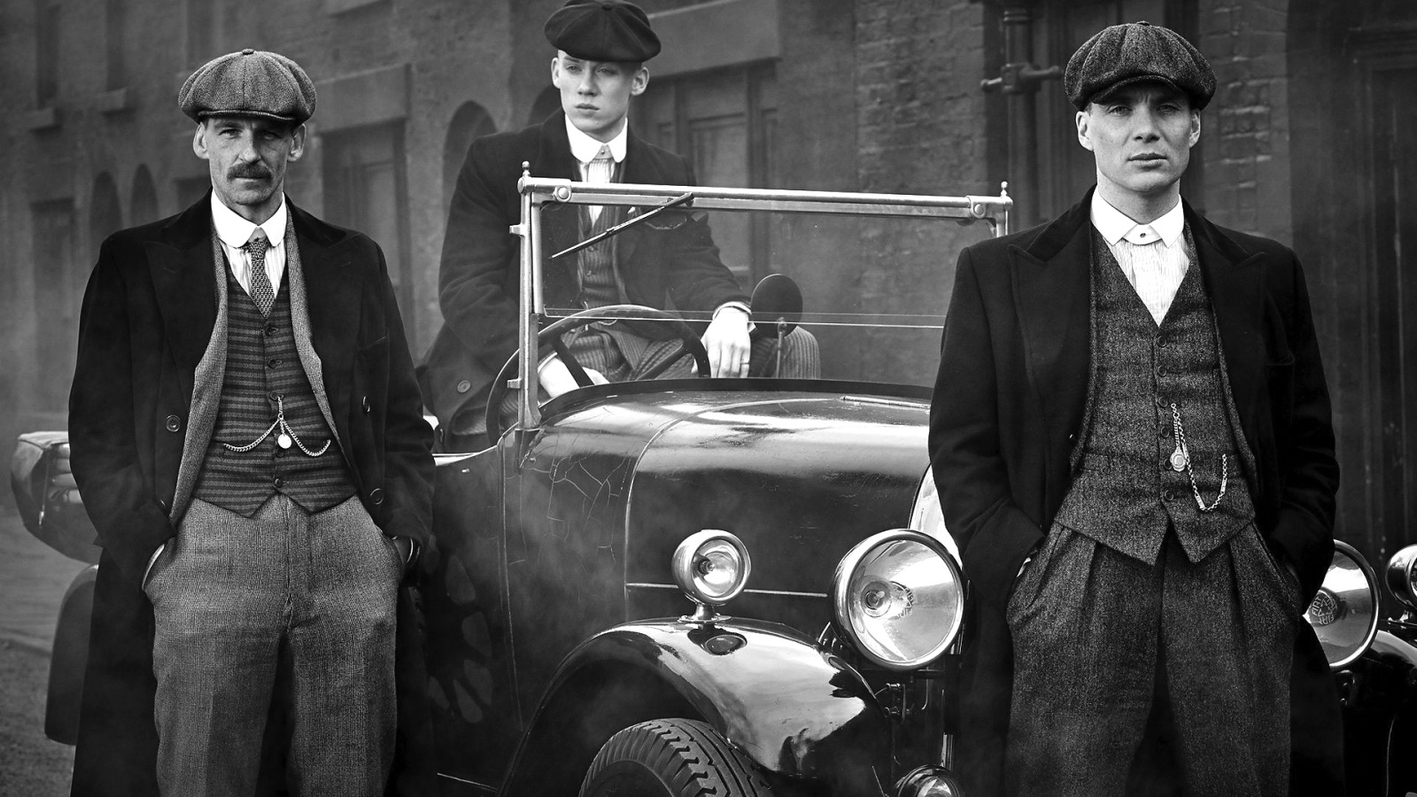 All three Peaky Blinders posing by their car