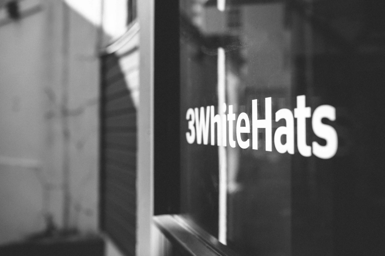 3 white hats building with logo on the window