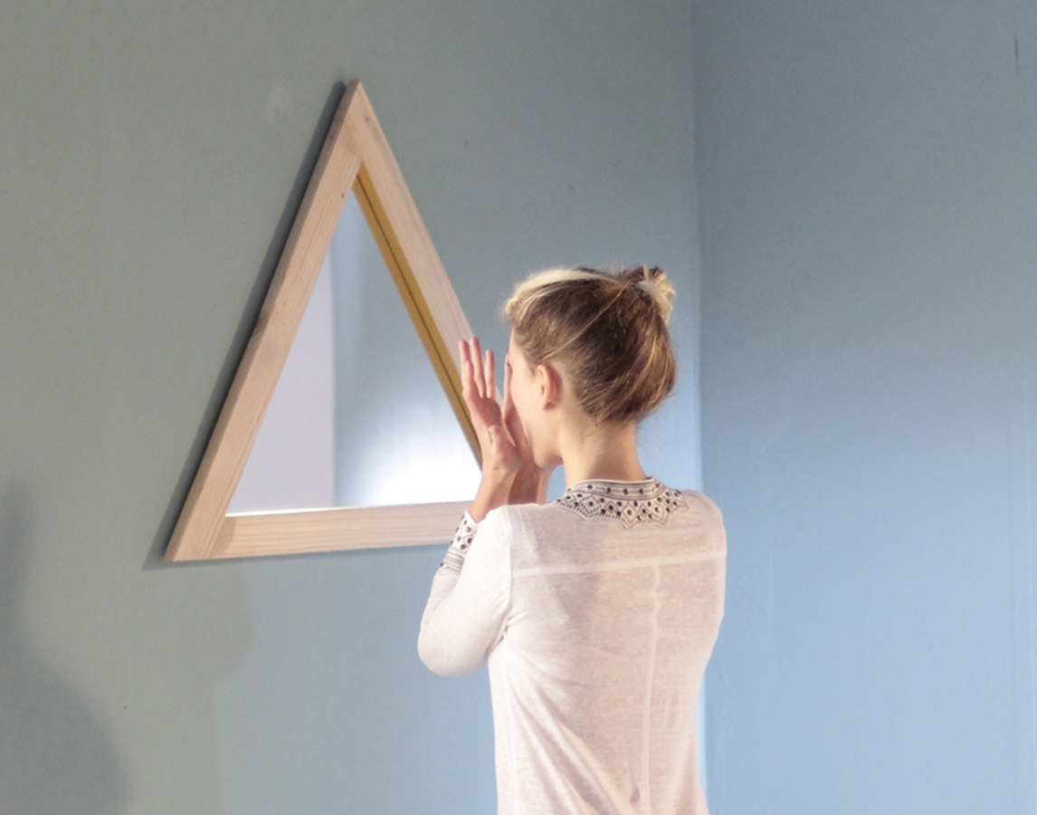 Curious fish on set with a woman looking into a triangular mirror