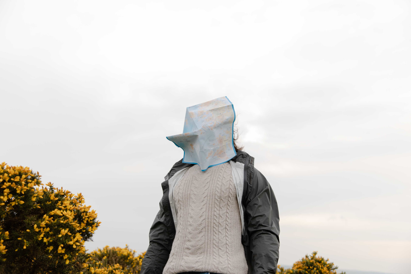 Woman with map blowing over face