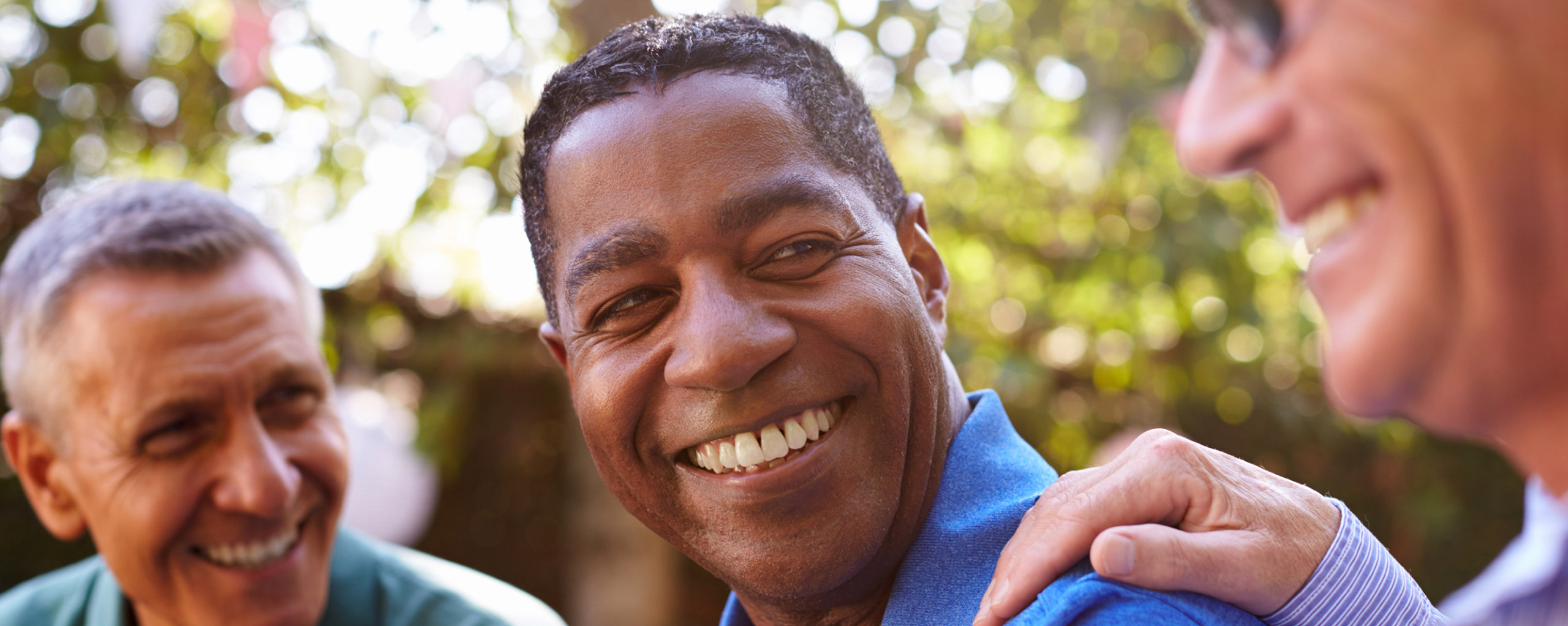 The Hearing Care Partnership image of three friends laughing in the garden