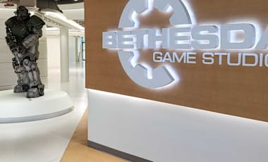 A suit of power armor from the Fallout series stands next to the "Bethesda Game Studios" sign lit in the Bethesda Game Studios lobby.