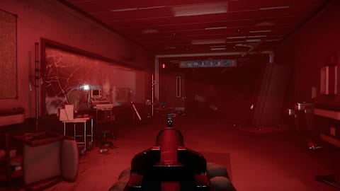 A modern-day hallway is bathed in red light.