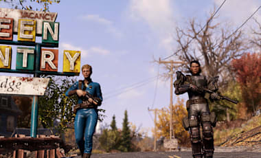 A large rusted sign for the Green Country Lodge sits on a roadside. A lone character in a Vault Suit and carrying a weapon walks along the road.