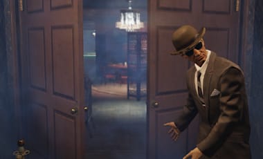 A man in a suit welcoming you into a room.
