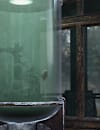 Large green-lit fish tank with a fish inside a rustic C.A.M.P., fishing lures on a shelf and forest visible through the window.