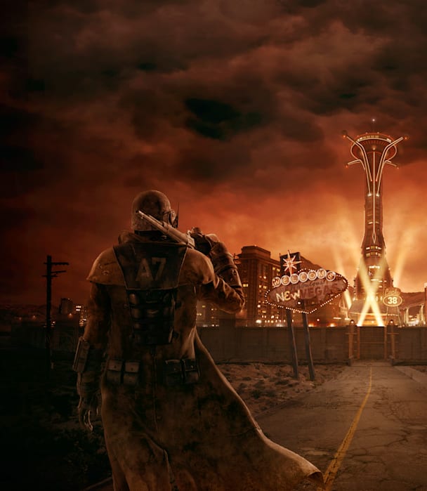 Still from the Fallout TV show. The Ghoul and CX404 sit near a corpse in the middle of a desert.