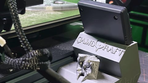 The GameQraft logo, printed onto a tablet stand.