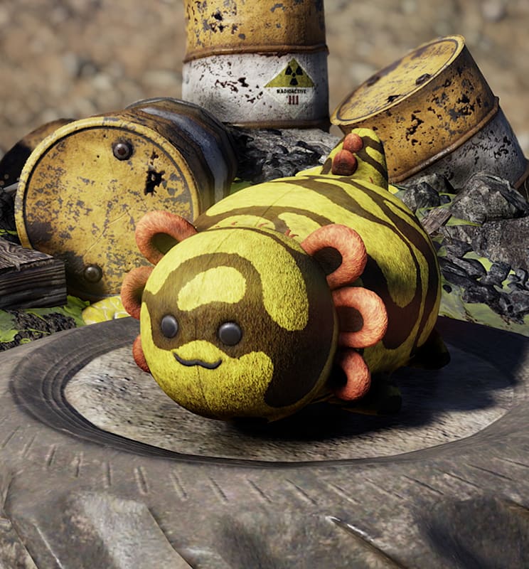 Yellow and black Banded Axolotl plushie rests on a tire amid cracked rocks and yellow radioactive waste barrels in a Fallout 76 wasteland camp