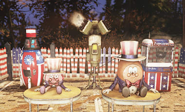 A festive outdoor Fallout 76 scene showcasing the Patriotic Bash bundle. It features the Patriotic Nuka-Cola Mystery Machine, the Weather Control Station (Fireworks), a red-white-and-blue popcorn machine, and a fence painted with American flag stripes. In the foreground are the Patriotic Cappy Plushie and Patriotic Bottle Plushie, both dressed in Uncle Sam hats.