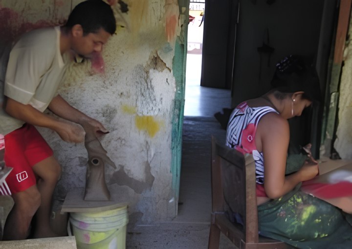 Beilka de Medoza paints while Carlos Calderon sculpts yet another piece for the local market.