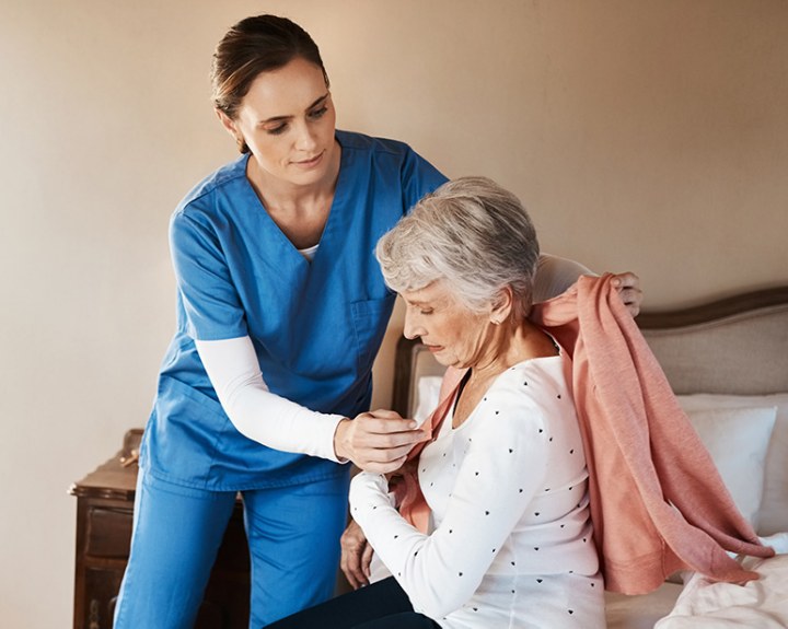 Putting shirt on patient.