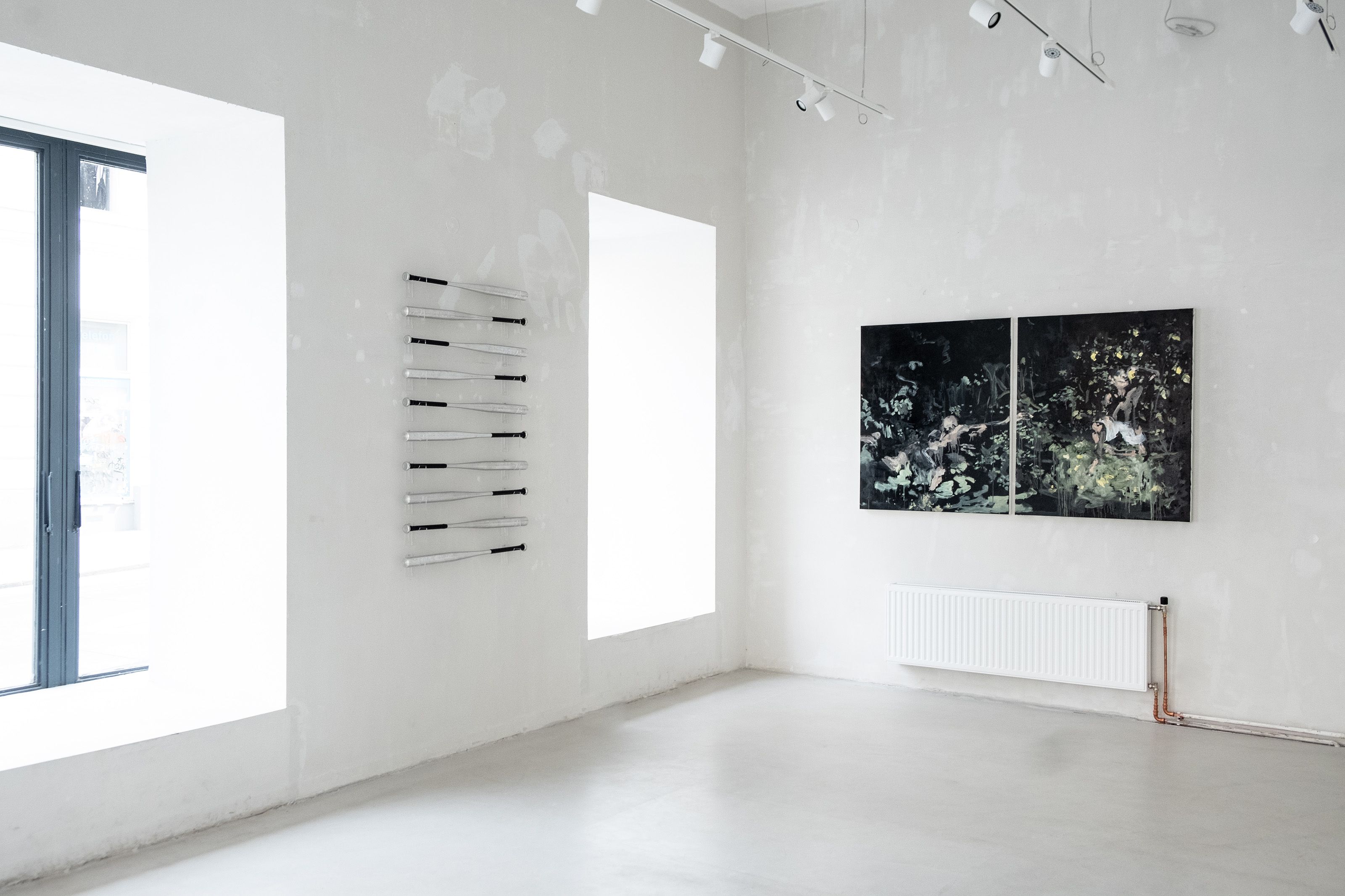 Exhibition setup with baseball bats and painting. 