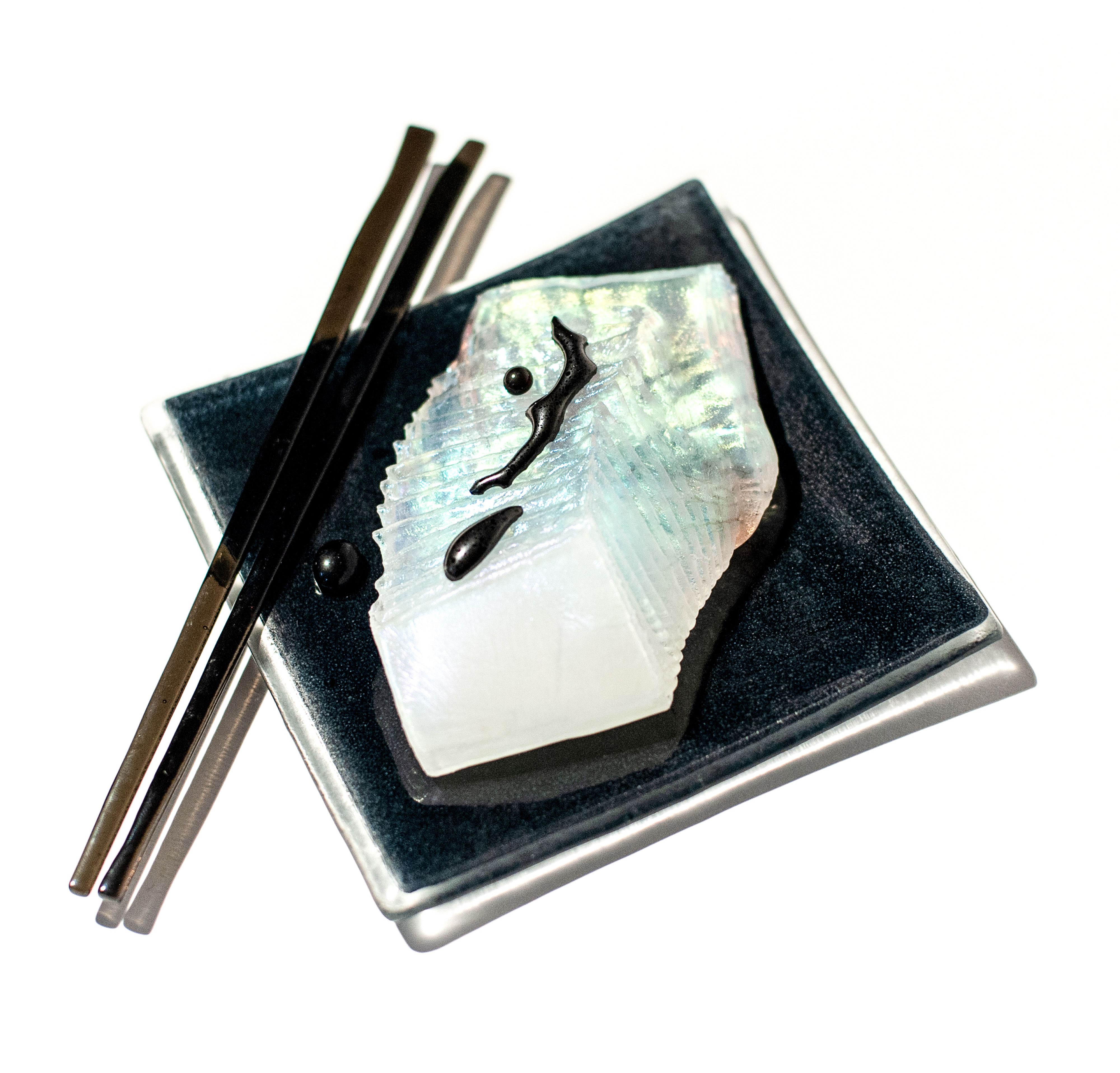 Fish filet with soy sauce, chopsticks and tray made from glass