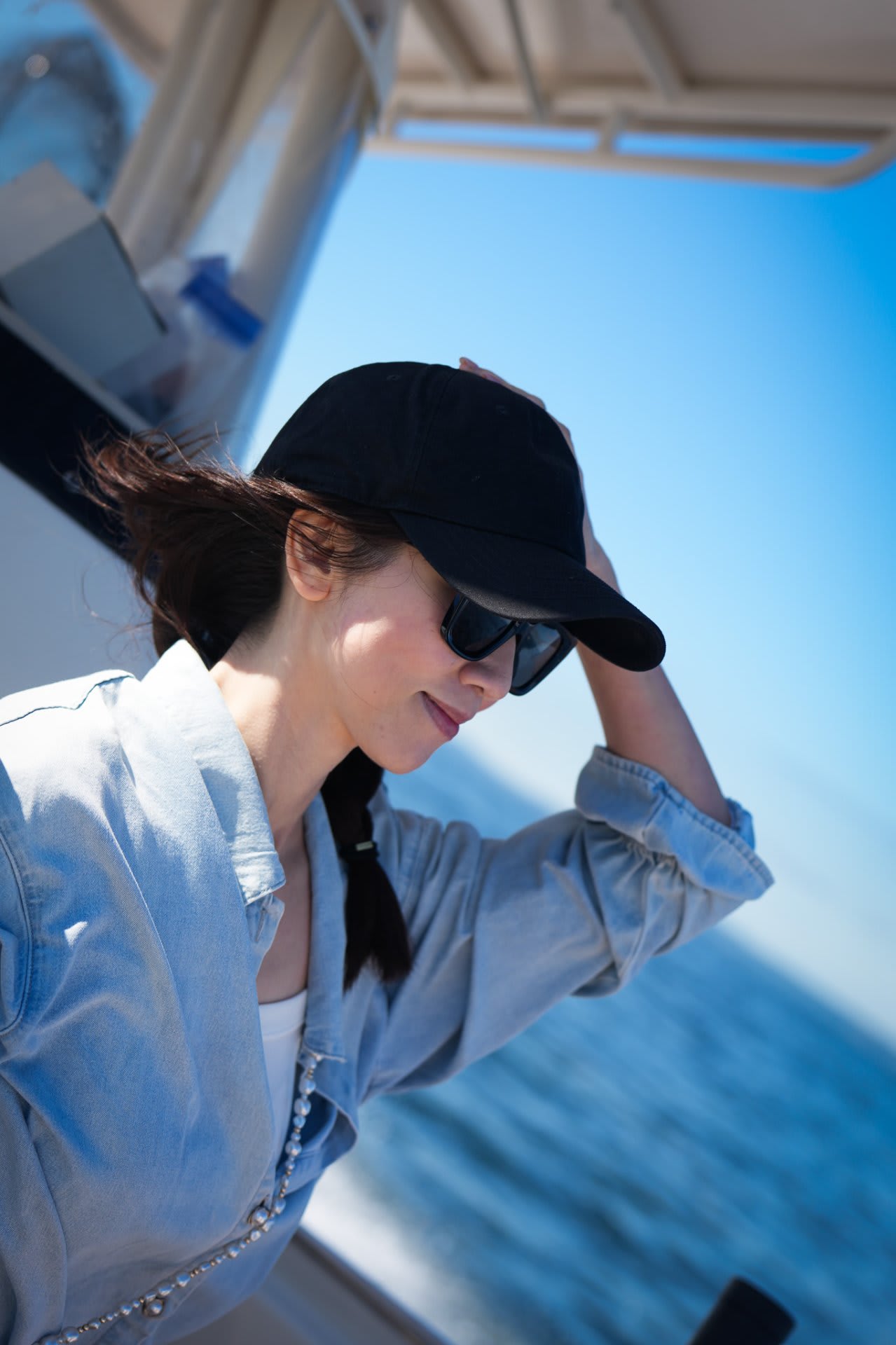 Maggie takes a quiet moment — hat in hand, wind in her hair, the Sound stretching out behind her