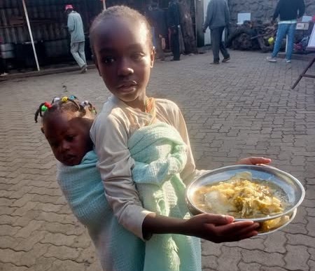 SCANN Hot Kitchen volunteers serving food to children