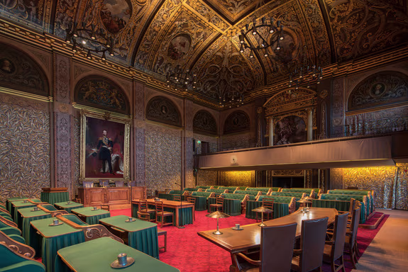 The imposing chamber of the Senate, with its green chairs, red floor, and richly decorated gilded ceiling mural.