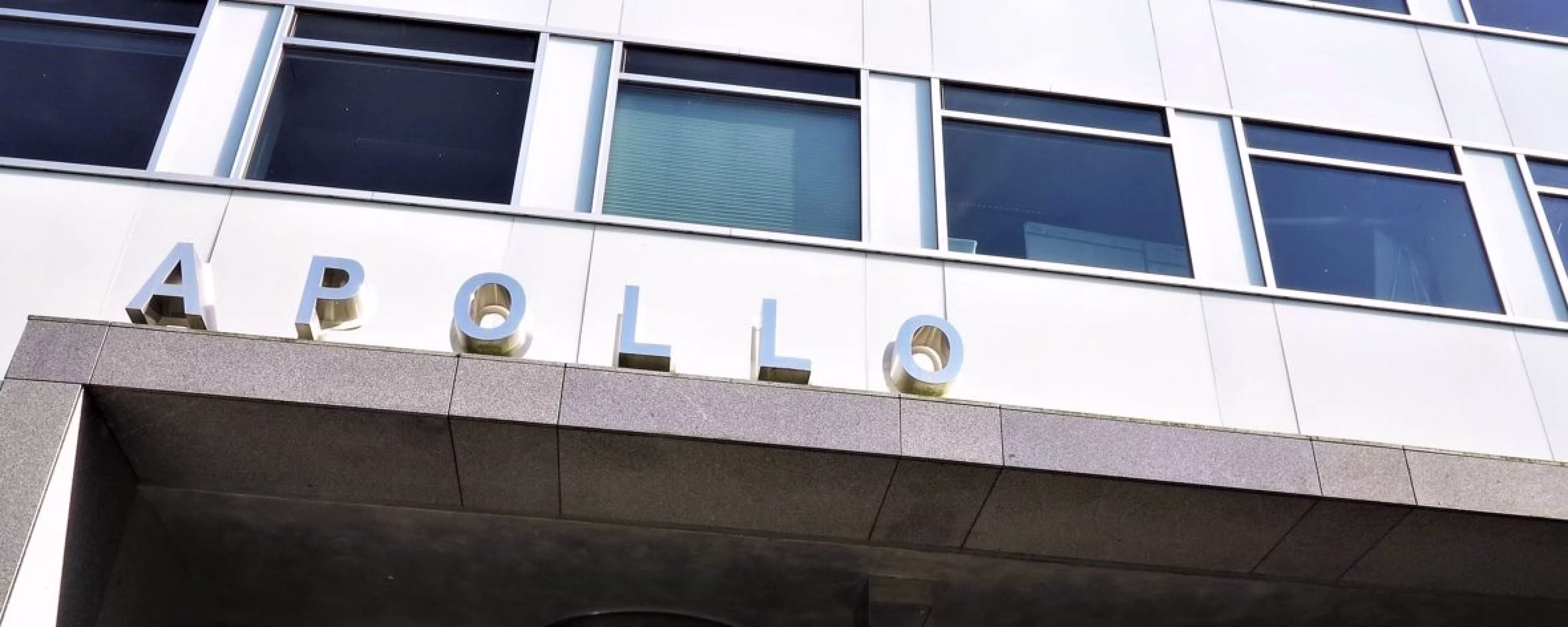 Buitenkant van het Apollo-gebouw met grote zilveren letters op de gevel en grote ramen.